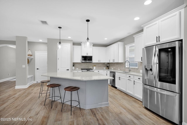 91 Rockhurst Trl, Jacksonville, FL 32081 - kitchen featuring appliances with stainless steel finishes, a sink, a kitchen island, tasteful backsplash, and white cabinetry