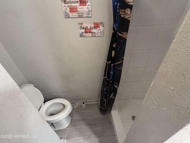 5362 Shen Ave, Jacksonville, FL 32205 - bathroom featuring toilet, a shower stall, and a textured wall