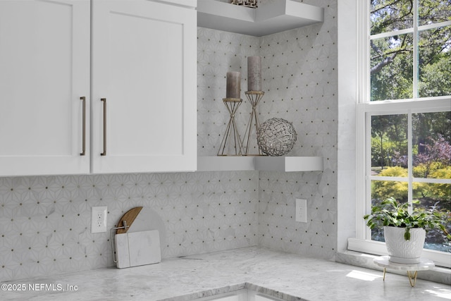2790 Joe Ashton Rd, Saint Augustine, FL 32092 - kitchen view of light stone counters, decorative backsplash, white cabinetry, and open shelves
