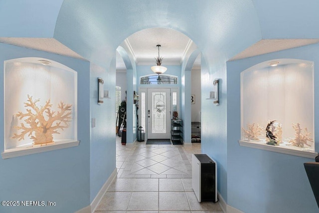 2918 Grande Oaks Way, Fleming Island, FL 32003 - entrance foyer featuring baseboards, light tile patterned flooring, arched walkways, and ornamental molding
