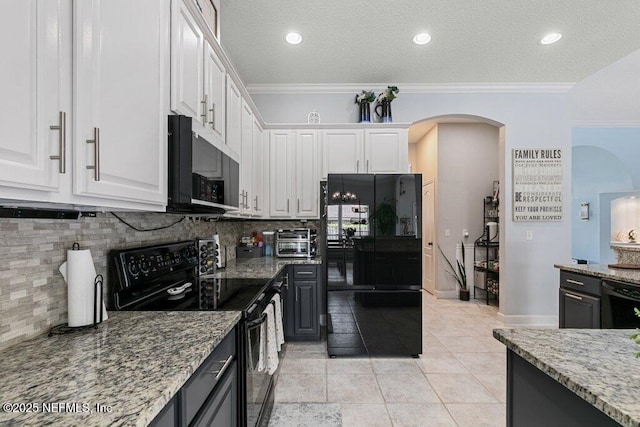 2918 Grande Oaks Way, Fleming Island, FL 32003 - kitchen with black appliances, arched walkways, white cabinets, light stone counters, and tasteful backsplash