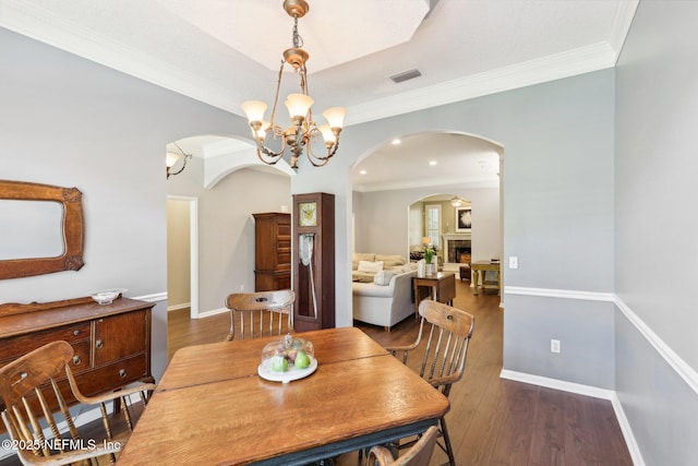 232 Shell Bluff Ct, Ponte Vedra Beach, FL 32082 - dining room featuring arched walkways, a chandelier, crown molding, wood finished floors, and baseboards
