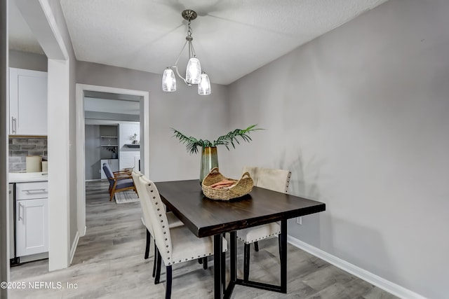 5916 Redberry Ln, Jacksonville, FL 32211 - dining space with light wood finished floors, a chandelier, and a textured ceiling