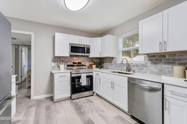 5916 Redberry Ln, Jacksonville, FL 32211 - kitchen with stainless steel appliances, a textured ceiling, light countertops, white cabinetry, and decorative backsplash