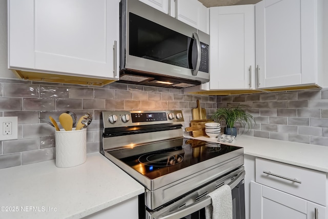 5916 Redberry Ln, Jacksonville, FL 32211 - kitchen featuring stainless steel appliances, white cabinetry, and tasteful backsplash