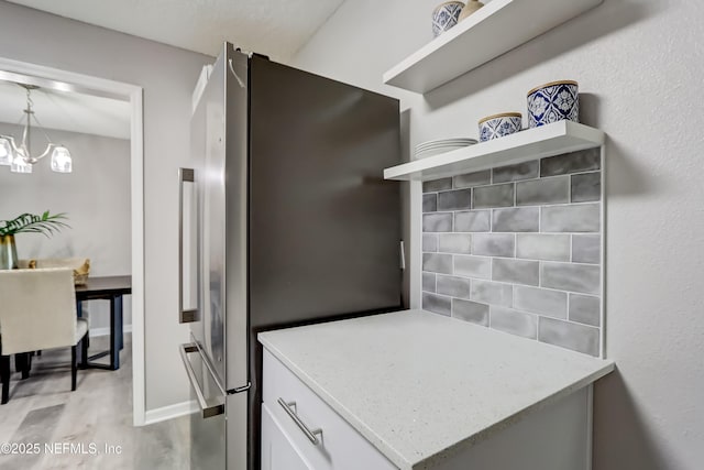 5916 Redberry Ln, Jacksonville, FL 32211 - kitchen featuring freestanding refrigerator, open shelves, white cabinetry, light wood-style flooring, and light stone countertops