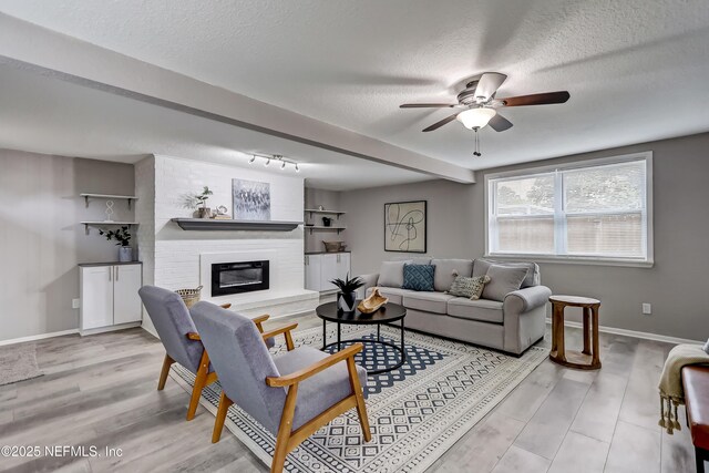 5916 Redberry Ln, Jacksonville, FL 32211 - living area with a textured ceiling, a ceiling fan, wood finished floors, and a brick fireplace