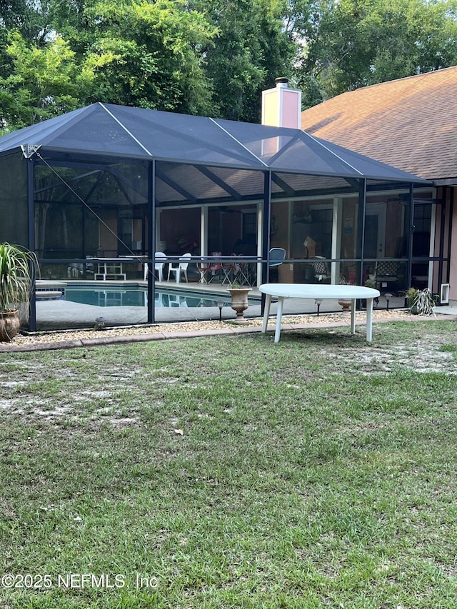 2840 Blackberry Ave, Middleburg, FL 32068 - rear view of house featuring an outdoor pool, a chimney, a yard, roof with shingles, and a lanai
