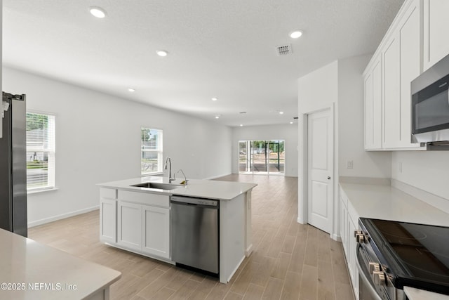 9053 Whinny Way, Jacksonville, FL 32219 - kitchen featuring stainless steel appliances, a sink, light wood-type flooring, white cabinetry, and light countertops