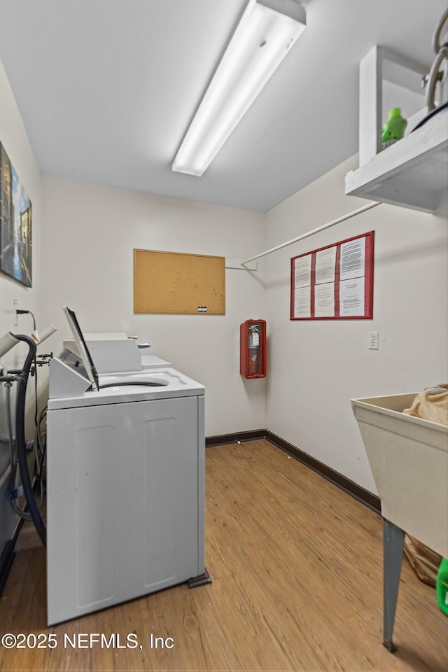 1255 Ponce Island Dr Unit F-779, Saint Augustine, FL 32084 - laundry room featuring washing machine and clothes dryer, light wood-style floors, and baseboards