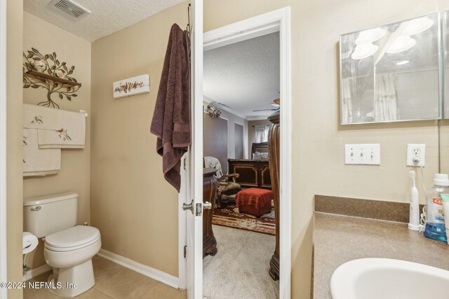 5346 Brighton Park Ln, Jacksonville, FL 32210 - ensuite bathroom featuring a textured ceiling, toilet, vanity, and baseboards
