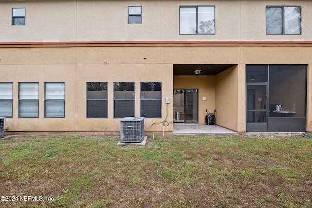 5346 Brighton Park Ln, Jacksonville, FL 32210 - rear view of property with central AC unit, stucco siding, a patio, and a lawn