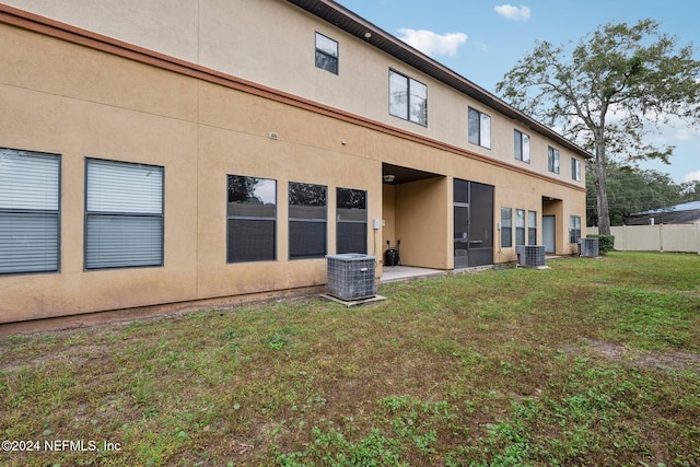 5346 Brighton Park Ln, Jacksonville, FL 32210 - back of house featuring stucco siding, central AC unit, and a patio