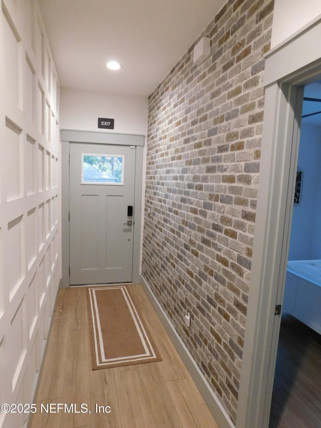 66 Oneida St, Saint Augustine, FL 32084 - doorway with brick wall and light wood finished floors