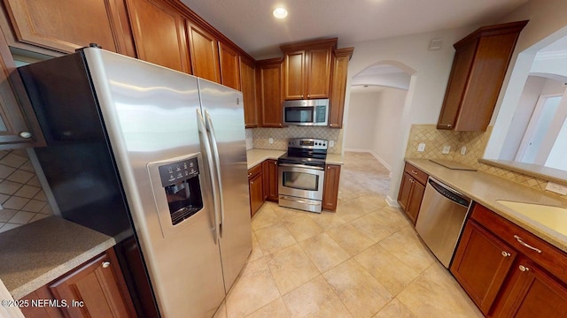 4480 Deerwood Lake Pkwy Unit 633, Jacksonville, FL 32216 - kitchen with appliances with stainless steel finishes, arched walkways, decorative backsplash, light countertops, and recessed lighting