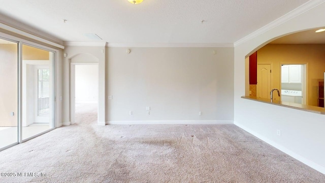 4480 Deerwood Lake Pkwy Unit 633, Jacksonville, FL 32216 - unfurnished living room featuring crown molding, arched walkways, carpet flooring, baseboards, and washer / dryer