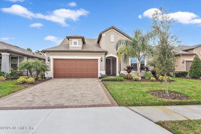 52 Bent Lake Ct, Saint Augustine, FL 32095 - view of front facade with stucco siding, decorative driveway, a front lawn, and an attached garage