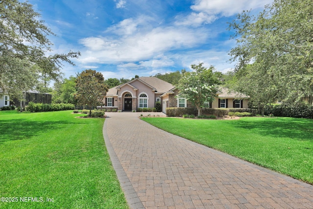 104 Hickory Hill Dr, Saint Augustine, FL 32095 - view of front of property featuring curved driveway, stucco siding, a front yard, and stone siding