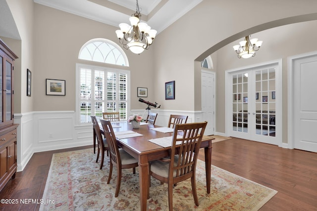 104 Hickory Hill Dr, Saint Augustine, FL 32095 - dining space featuring a chandelier, french doors, dark wood-type flooring, arched walkways, and crown molding