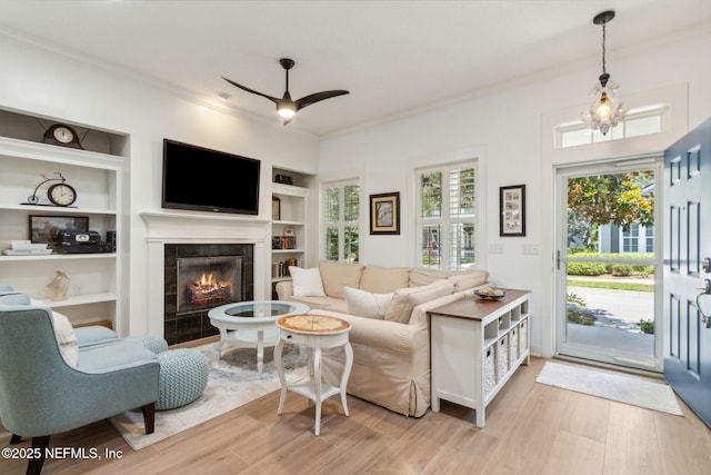 1743 Azalea St, Fernandina Beach, FL 32034 - living area with ornamental molding, a ceiling fan, built in features, a fireplace, and light wood finished floors