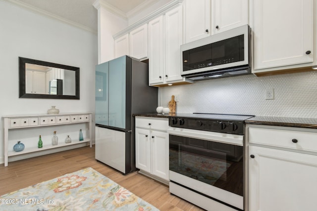 1743 Azalea St, Fernandina Beach, FL 32034 - kitchen with white appliances, ornamental molding, backsplash, white cabinets, and light wood-style flooring