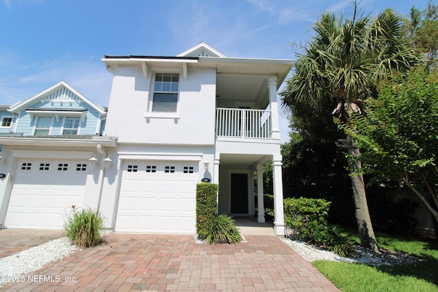 58 Islander Cir, Saint Augustine, FL 32080 - view of front of house featuring a balcony, a garage, decorative driveway, and stucco siding