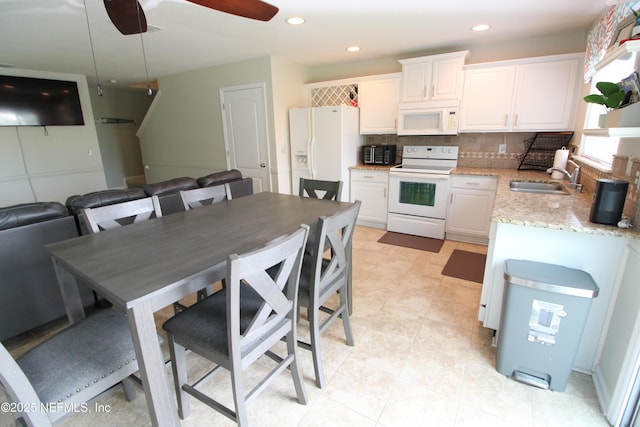 58 Islander Cir, Saint Augustine, FL 32080 - kitchen with white appliances, a sink, white cabinets, decorative backsplash, and a ceiling fan