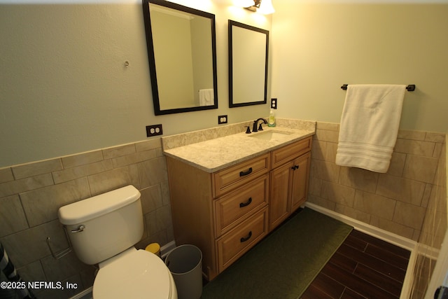 58 Islander Cir, Saint Augustine, FL 32080 - bathroom with tile walls, wood finished floors, vanity, wainscoting, and toilet