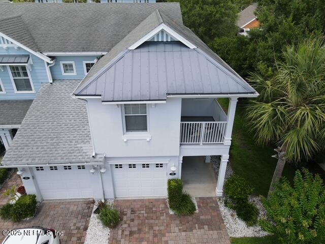 58 Islander Cir, Saint Augustine, FL 32080 - view of front of home with a garage, a balcony, decorative driveway, a shingled roof, and a standing seam roof