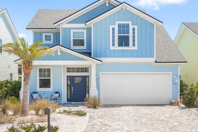 125 5th St, Saint Augustine, FL 32080 - view of front facade featuring board and batten siding, a shingled roof, driveway, and a garage