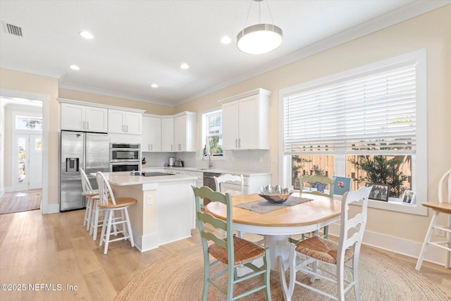 125 5th St, Saint Augustine, FL 32080 - dining room with ornamental molding, recessed lighting, light wood-type flooring, and baseboards