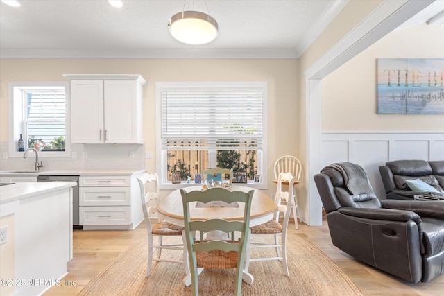 125 5th St, Saint Augustine, FL 32080 - dining space with crown molding, light wood-style floors, and a wainscoted wall