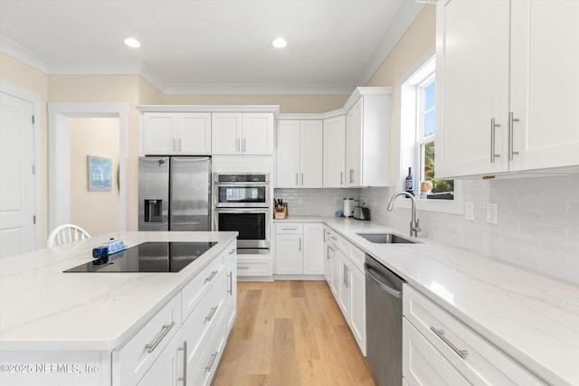 125 5th St, Saint Augustine, FL 32080 - kitchen with stainless steel appliances, a sink, white cabinets, crown molding, and decorative backsplash
