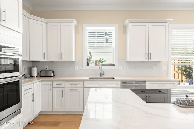125 5th St, Saint Augustine, FL 32080 - kitchen with a sink, stainless steel appliances, white cabinetry, and decorative backsplash