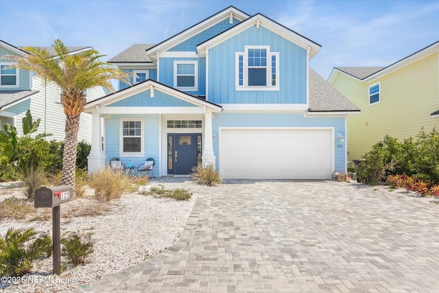 125 5th St, Saint Augustine, FL 32080 - view of front of property featuring driveway, board and batten siding, a porch, an attached garage, and roof with shingles