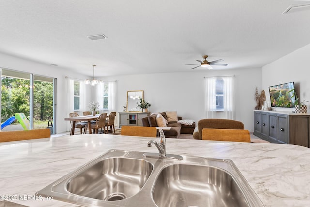 1305 Panther Lk Parkway, Jacksonville, FL 32221 - kitchen with a sink, ceiling fan, light stone counters, decorative light fixtures, and a chandelier