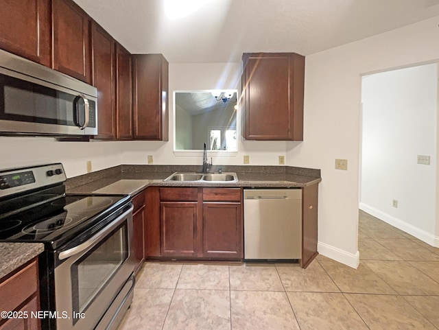 624 Staffordshire Dr, Jacksonville, FL 32225 - kitchen with appliances with stainless steel finishes, a sink, dark countertops, light tile patterned flooring, and baseboards