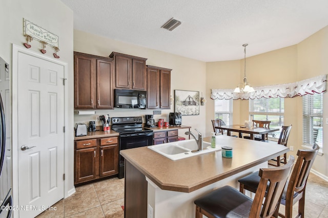 104 Twin Lakes Dr, Saint Augustine, FL 32084 - kitchen with black appliances, a sink, a chandelier, a center island with sink, and a breakfast bar