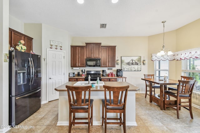 104 Twin Lakes Dr, Saint Augustine, FL 32084 - kitchen featuring refrigerator with ice dispenser, black microwave, stove, a kitchen island with sink, and a chandelier