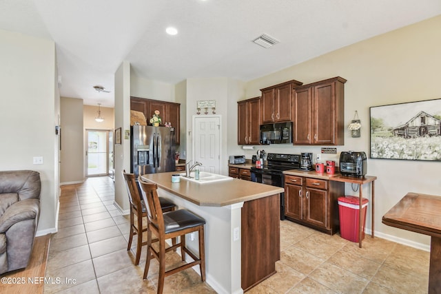 104 Twin Lakes Dr, Saint Augustine, FL 32084 - kitchen featuring black appliances, a sink, light tile patterned flooring, a kitchen breakfast bar, and recessed lighting