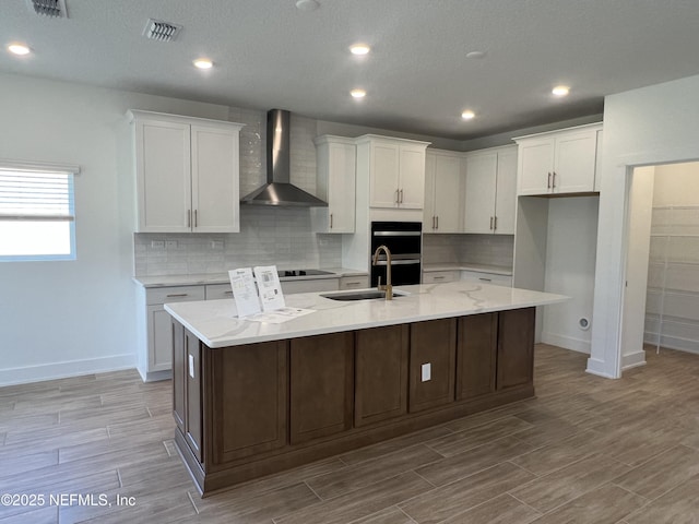 96124 Pirates Bluff Rd, Yulee, FL 32097 - kitchen with wall chimney range hood, white cabinetry, a large island, double oven, and wood finished floors