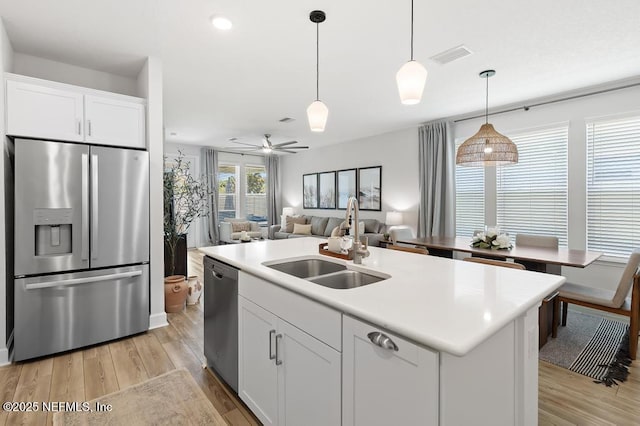 9789 Intellect Trl, Jacksonville, FL 32256 - kitchen featuring stainless steel appliances, a sink, open floor plan, and light wood-style flooring