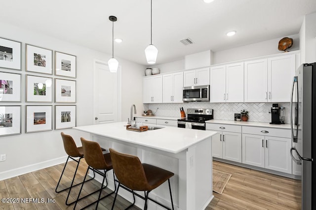 9789 Intellect Trl, Jacksonville, FL 32256 - kitchen featuring stainless steel appliances, a sink, a breakfast bar, white cabinetry, and recessed lighting