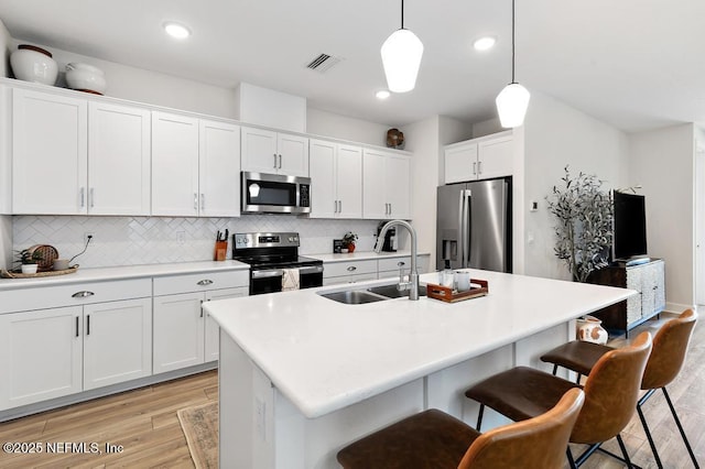 9789 Intellect Trl, Jacksonville, FL 32256 - kitchen featuring stainless steel appliances, a sink, tasteful backsplash, hanging light fixtures, and a breakfast bar