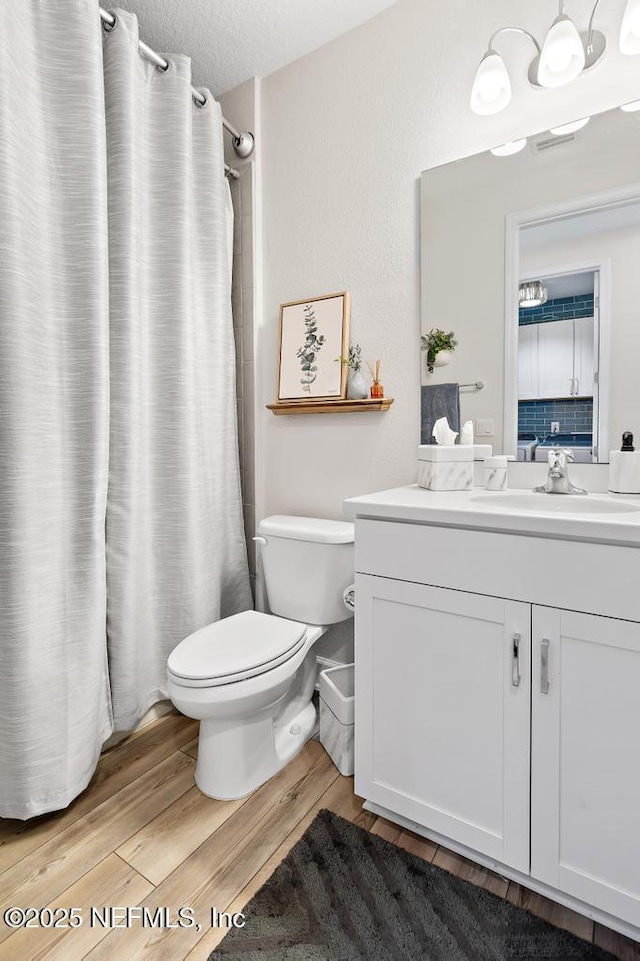 9789 Intellect Trl, Jacksonville, FL 32256 - full bathroom with toilet, vanity, wood finished floors, and a shower with curtain