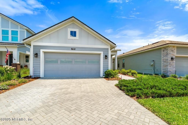 9789 Intellect Trl, Jacksonville, FL 32256 - view of front facade with decorative driveway, board and batten siding, and a garage