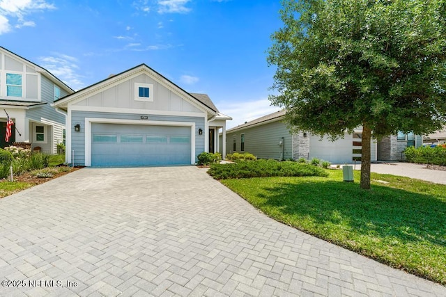 9789 Intellect Trl, Jacksonville, FL 32256 - ranch-style home with board and batten siding, decorative driveway, a front yard, and an attached garage
