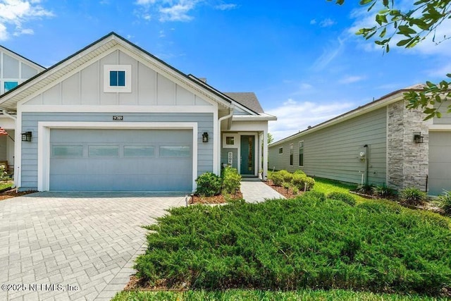 9789 Intellect Trl, Jacksonville, FL 32256 - view of front of home with board and batten siding, decorative driveway, and a garage