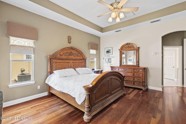 1159 Eastwood Branch Dr, Saint Johns, FL 32259 - bedroom with baseboards, wood finished floors, arched walkways, a ceiling fan, and a tray ceiling