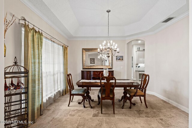 1159 Eastwood Branch Dr, Saint Johns, FL 32259 - dining area with arched walkways, crown molding, baseboards, light stone finish flooring, and a chandelier